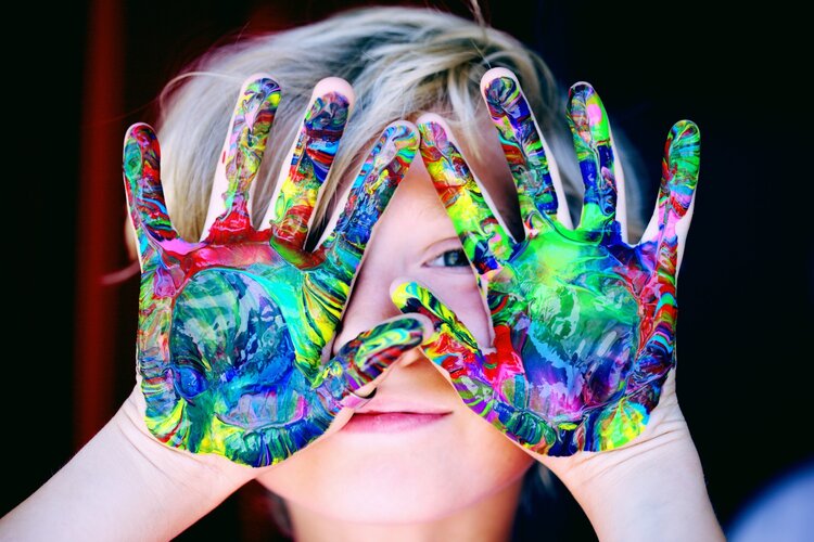 Un enfant avec de la peinture sur les mains.